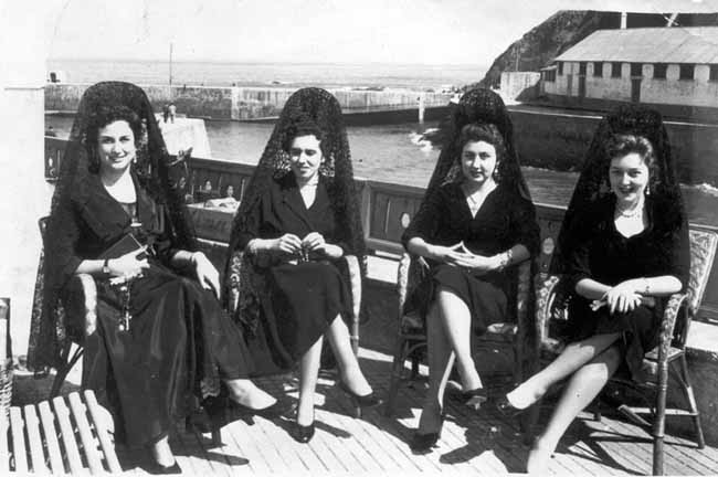 Imagen - Mujeres con mantilla en la procesión del Santo Entierro en la Semana Santa de Luarca, año 1954